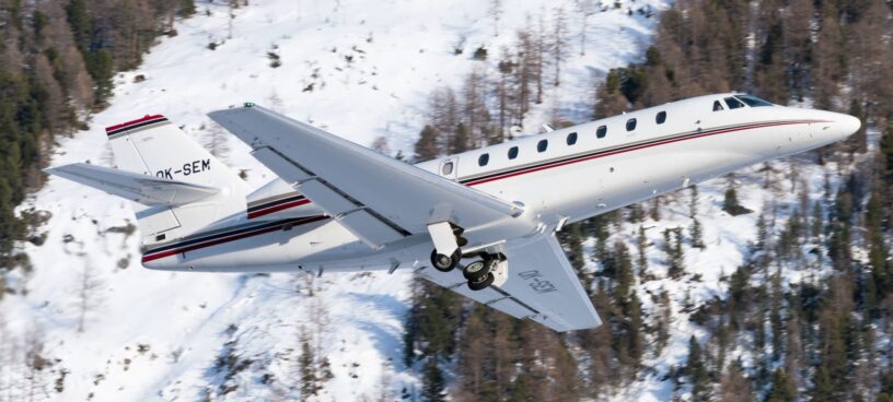 super-midsize-jet-banner-Citation Sovereign Ein Super Midsize Privatjet fliegt an einem beschneiten Gebiet entlang